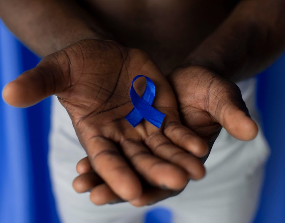 homem segurando um laço em homenagem ao outubro rosa e novembro azul